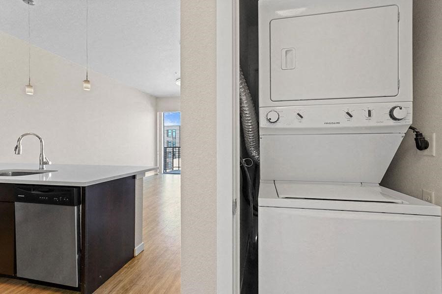A white dishwasher is in a kitchen next to a sink at Wash Park Station in Denver, CO