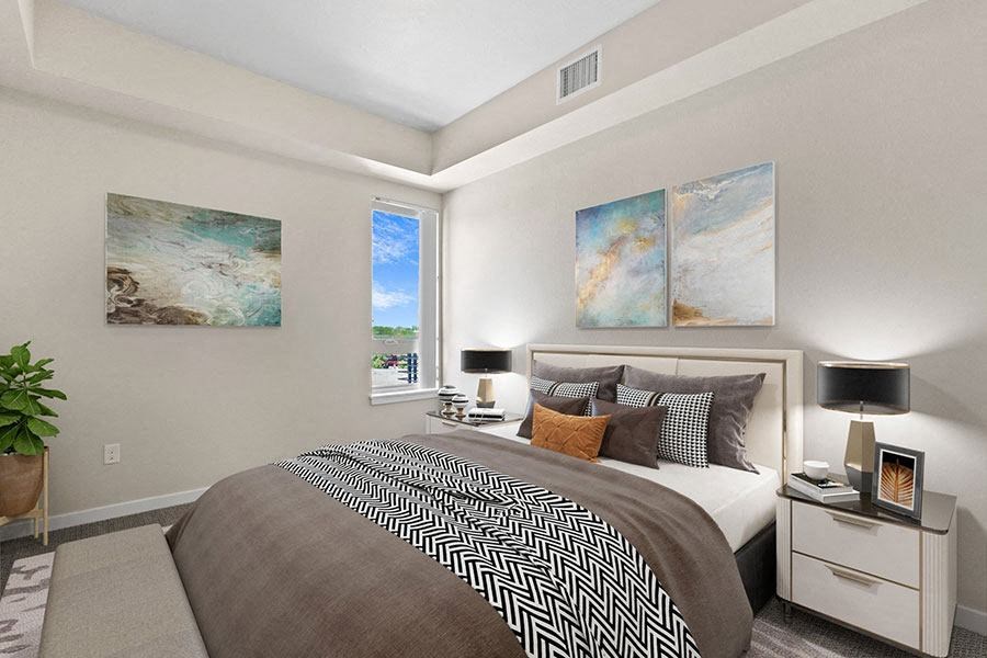 A bedroom with a large bed and two paintings on the wall at Wash Park Station in Denver, CO