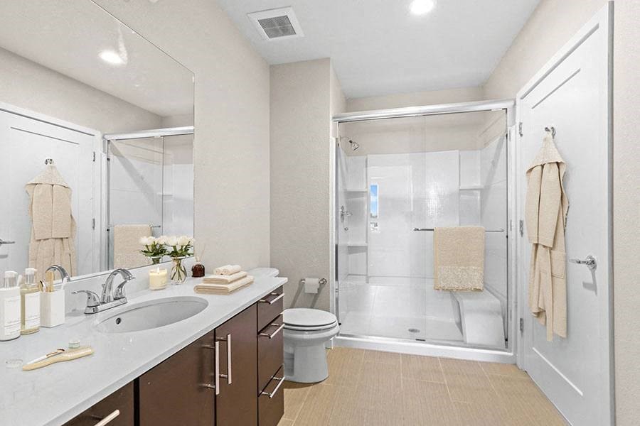 A bathroom with a toilet, sink, and shower.