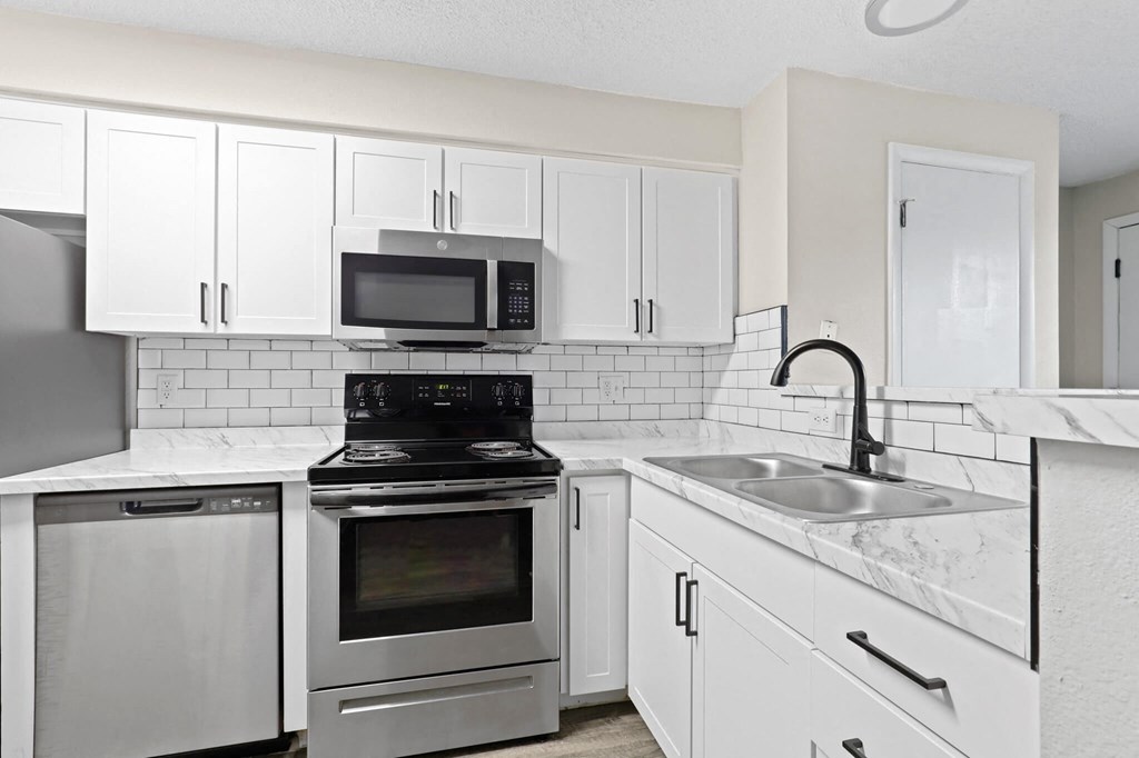 a kitchen with stainless steel appliances and white cabinets