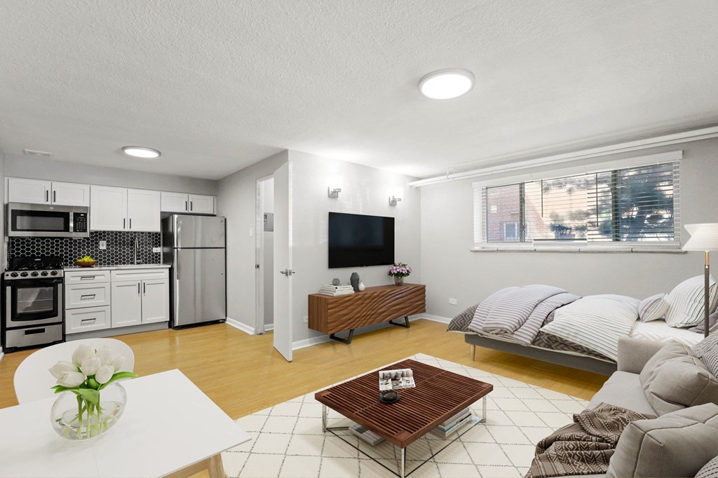 A modern living room with a kitchen area in the background at 1355 Pearl in Denver, CO