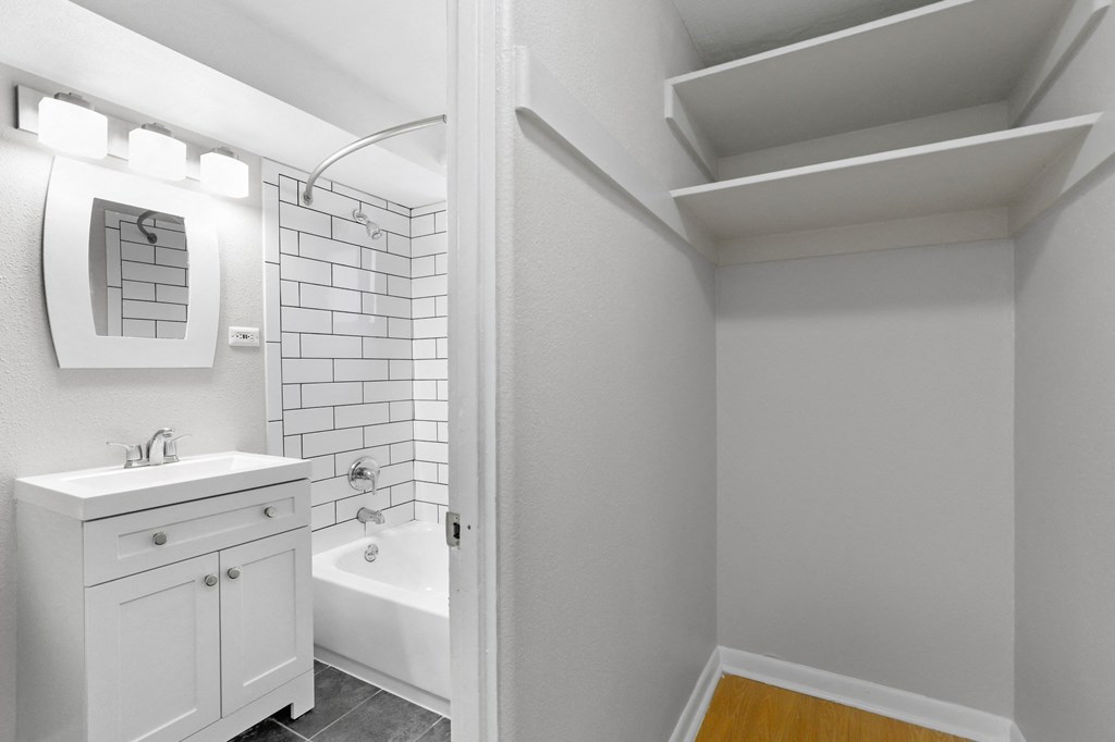 A white bathroom with a white cabinet and a white tub at 1355 Pearl in Denver, CO