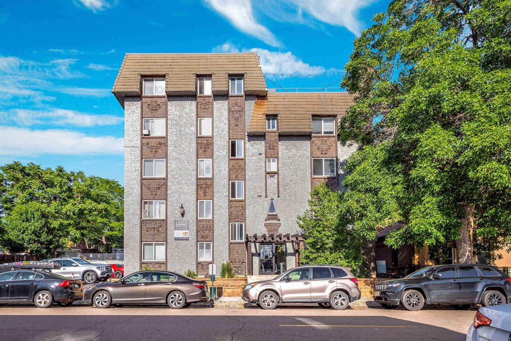 a apartment building with cars parked in front of it