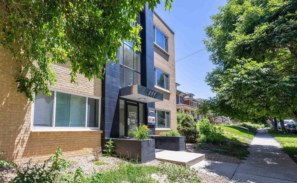 a brick building with a sidewalk in front of it