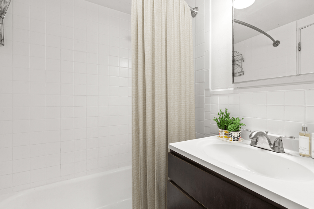 a bathroom with a sink and a shower next to a tub