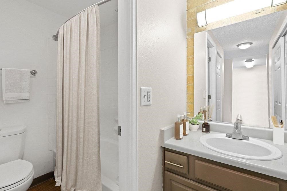 a bathroom with a shower and a sink and a mirror