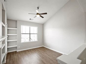 A living room with a ceiling fan and a window