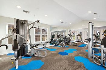 State-of-the-art fitness center with weight machines, cardio equipment, and blue-accented flooring for a modern athletic feel.
