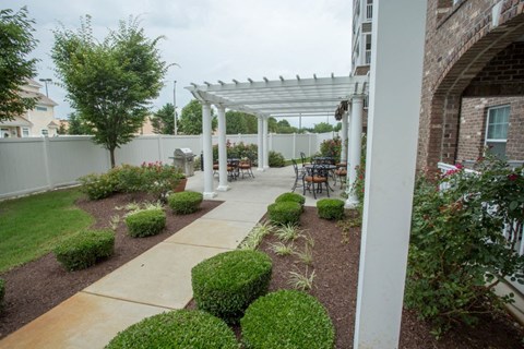 A patio with a white pergola and a white pillar.