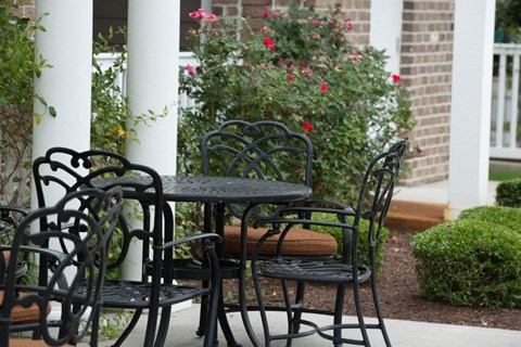 A table and chairs set outside on a porch.