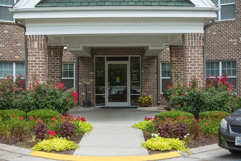 A building entrance with a brick wall and a yellow walkway.