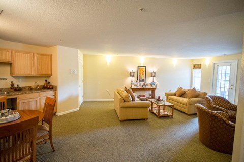 A living room with a couch, chairs, and a dining table.