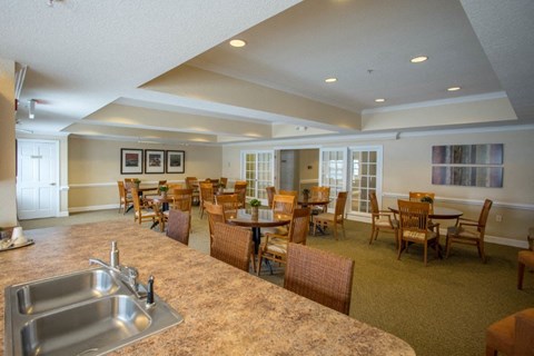 A kitchen with a sink and chairs.