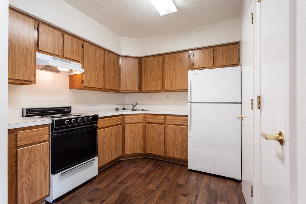 A kitchen with wooden cabinets and a white refrigerator.