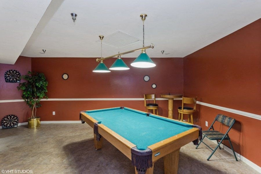 A pool table in a room with a brown wall.
