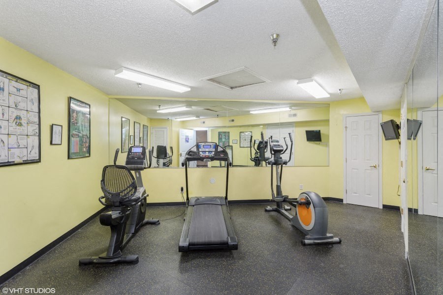 A gym with treadmills, elliptical machines, and other exercise equipment.