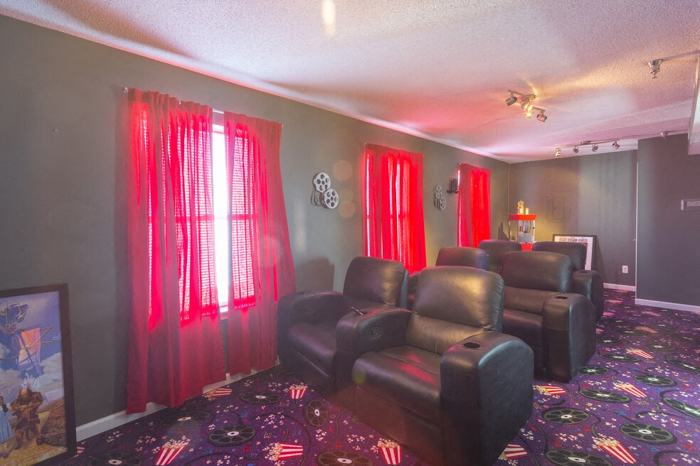 A room with red curtains and black leather chairs.