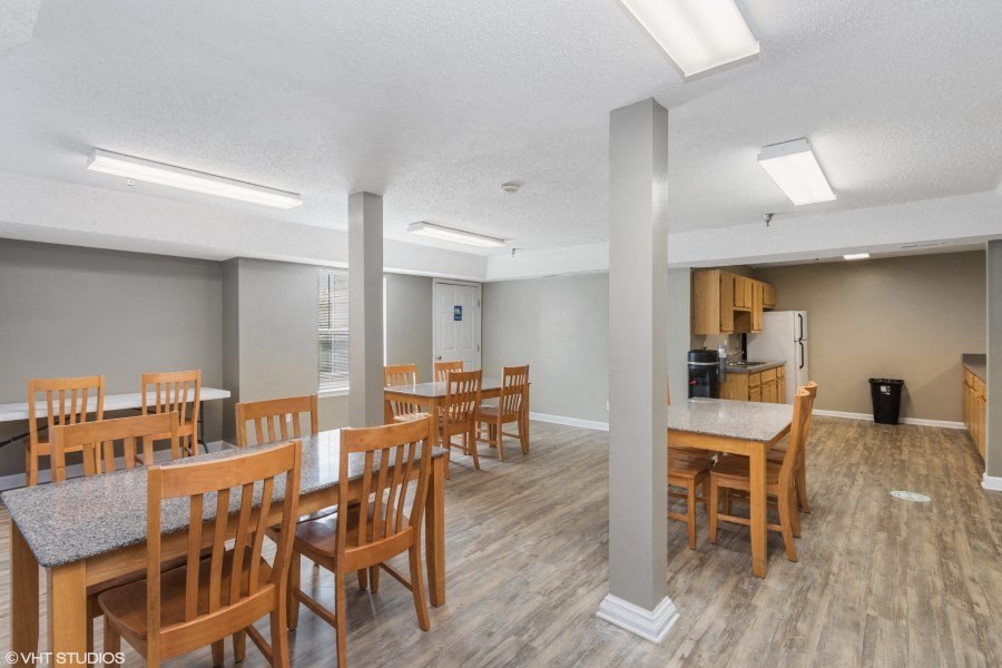A room with wooden chairs and tables is shown.