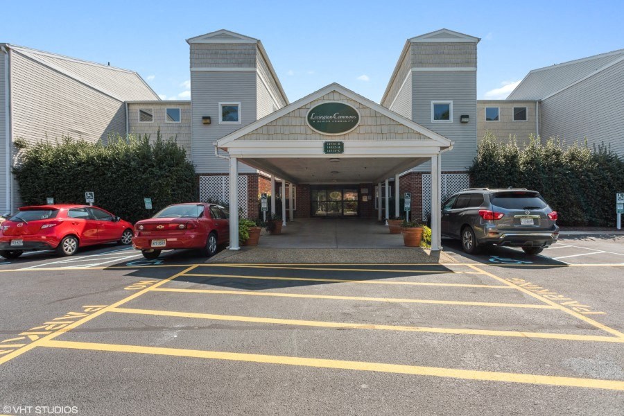 A parking lot with cars and a building entrance.