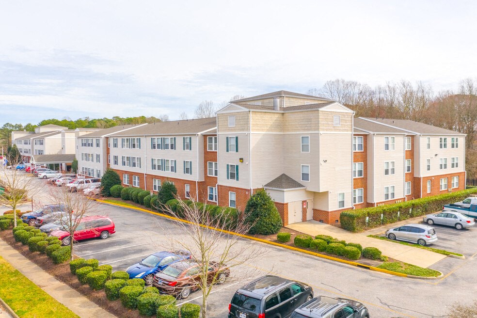 A parking lot in front of a multi-story apartment building.