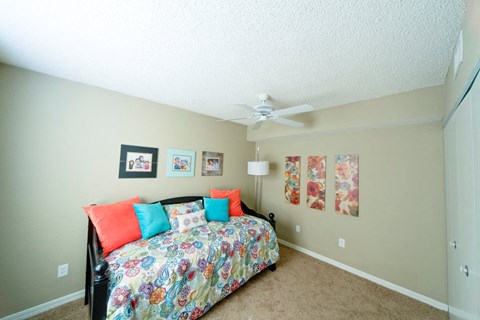 A bedroom with a bed, pillows, and pictures on the wall.
