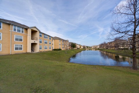 Apartment complex with a pond in front.