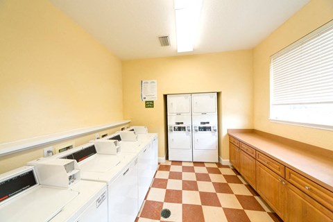 A laundry room with washers and dryers and a checkered floor.