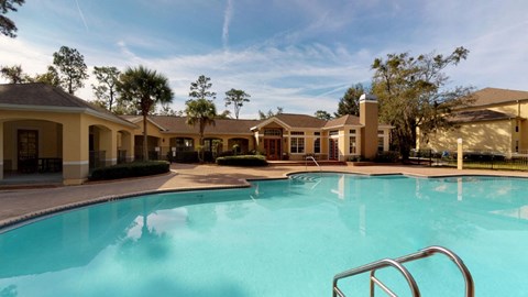 A swimming pool in front of a building with a metal ladder.
