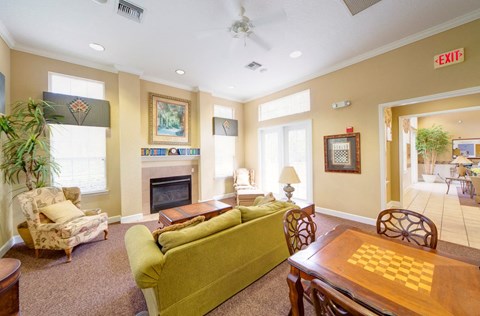 A living room with a green couch and a fireplace.
