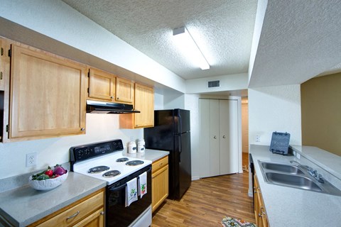 A kitchen with black appliances and wooden cabinets.