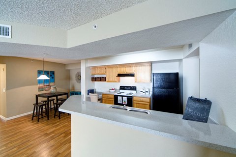 A kitchen with a white counter and a black fridge.