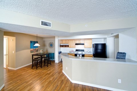 A kitchen with a bar and a dining table.