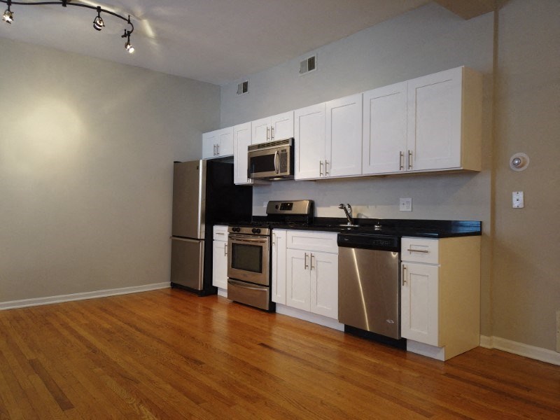A kitchen with white cabinets and stainless steel appliances.