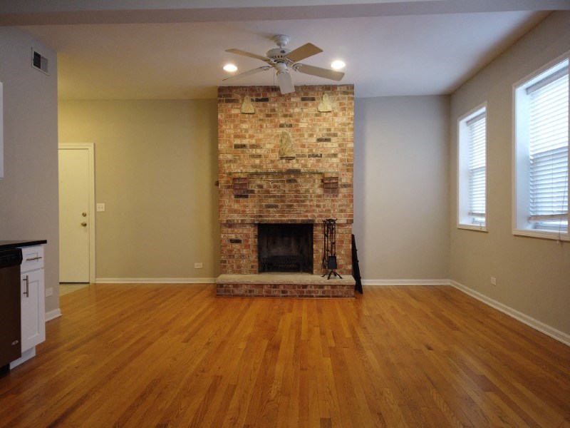 A room with a fireplace and a ceiling fan.