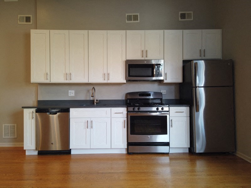 A kitchen with white cabinets and stainless steel appliances.