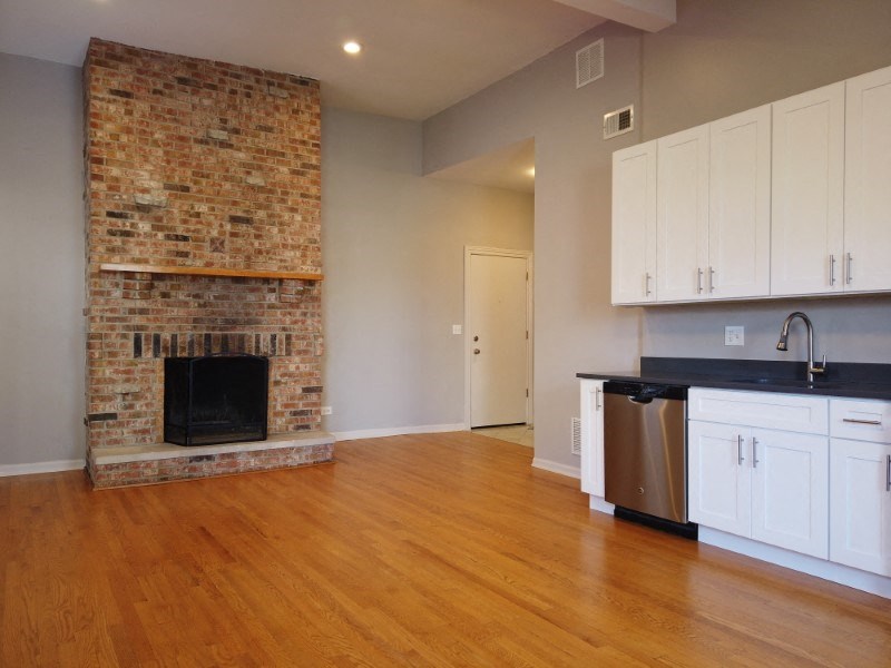 A room with a fireplace and wooden floors.
