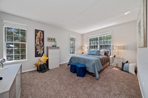 A bedroom with a bed, nightstand, and window.