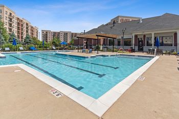 A large outdoor swimming pool with a building in the background.