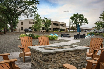 a patio with chairs and a fire pit
