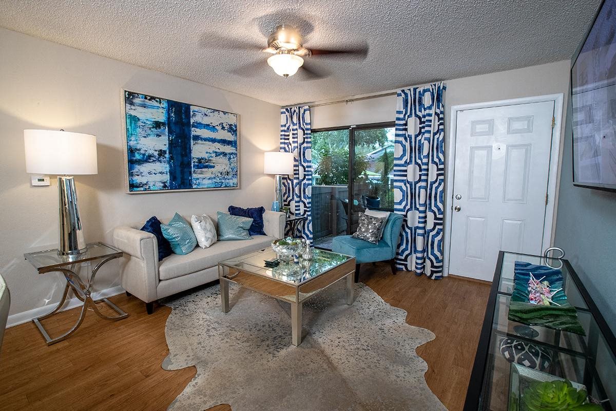 Spacious living room featuring wood-style flooring and a ceiling fan Spacious living room featuring wood-style flooring and a ceiling fan
