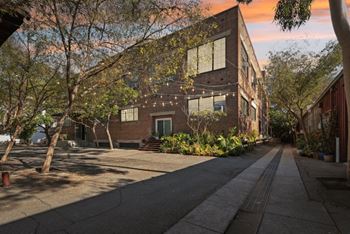 a brick house with a sidewalk in front of it