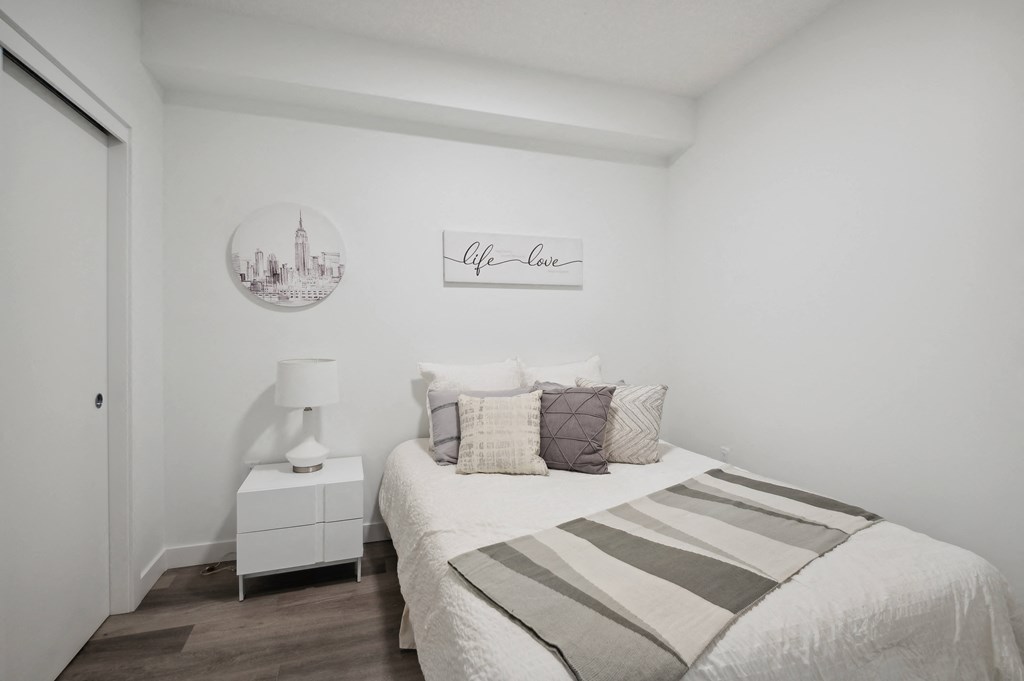 a bedroom with white walls and a bed with pillows