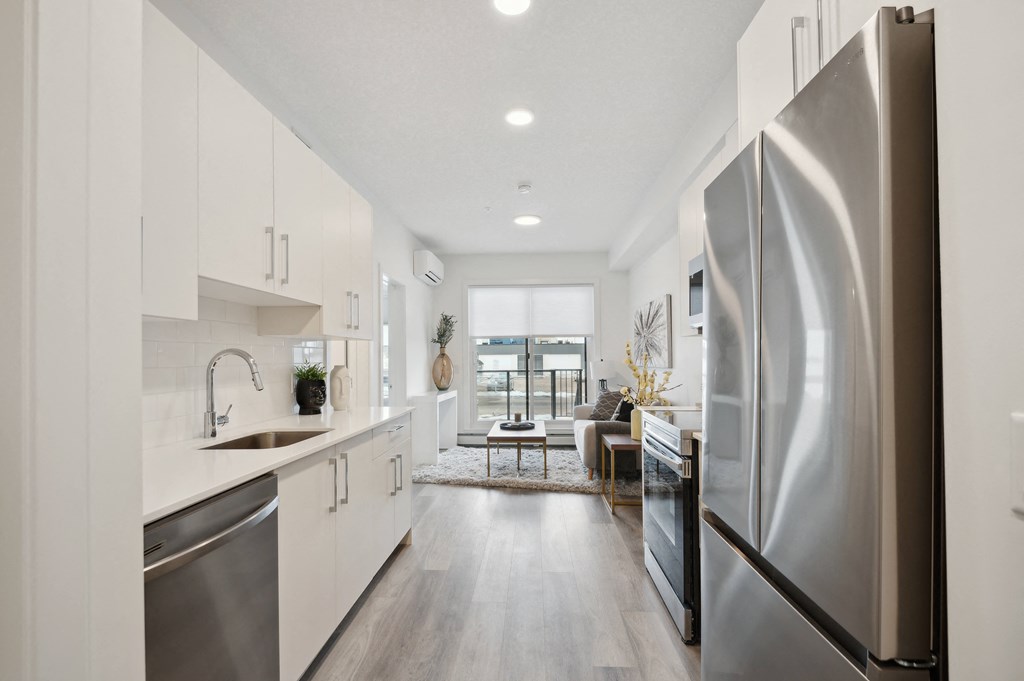 an open kitchen with stainless steel appliances and white cabinets