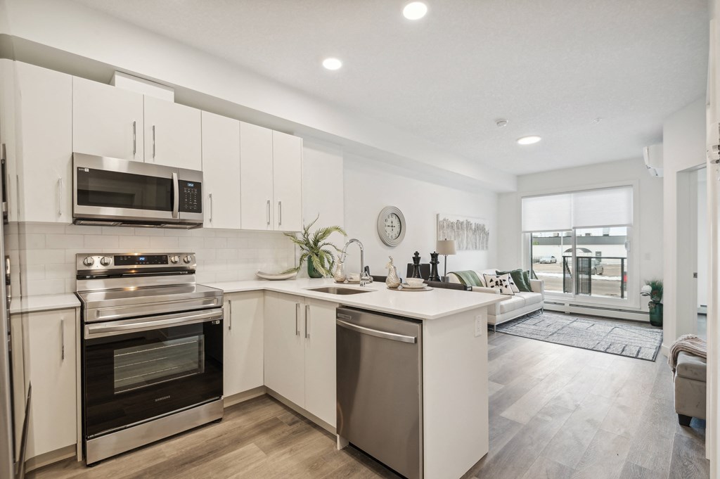 an open kitchen with white cabinets and stainless steel appliances