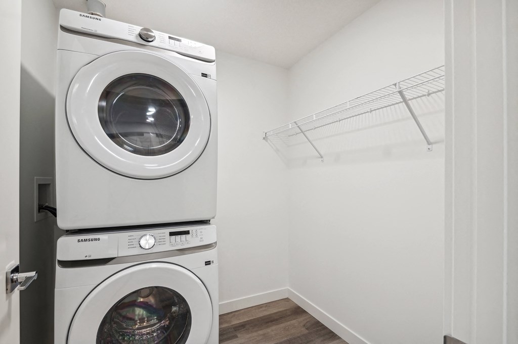 a front loading washer and dryer in a laundry room with a white closet