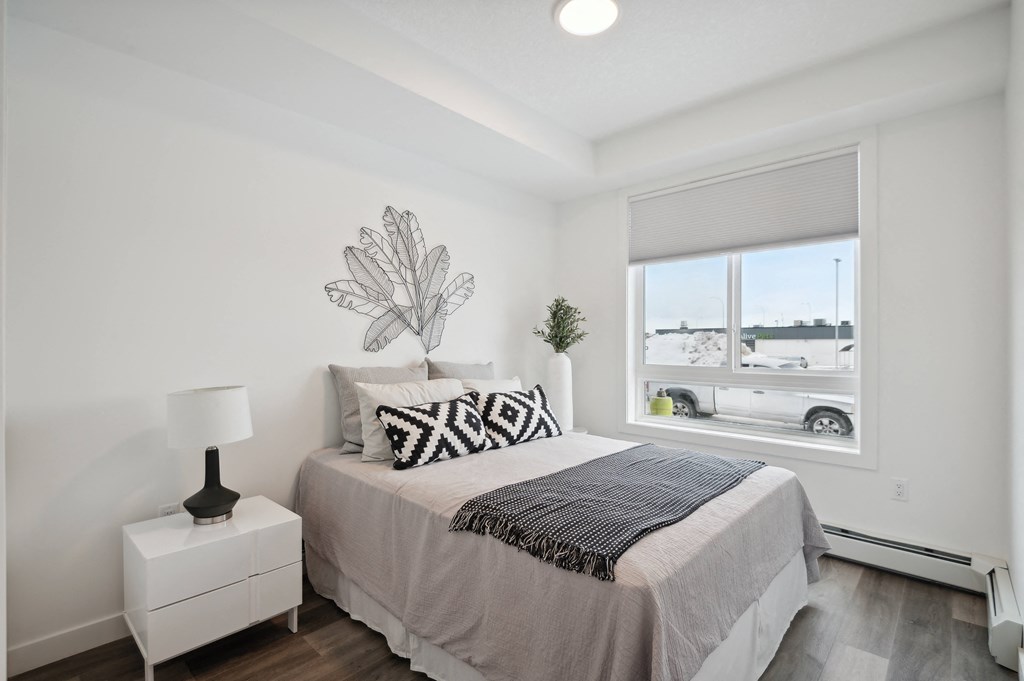 a bedroom with a bed and a large window