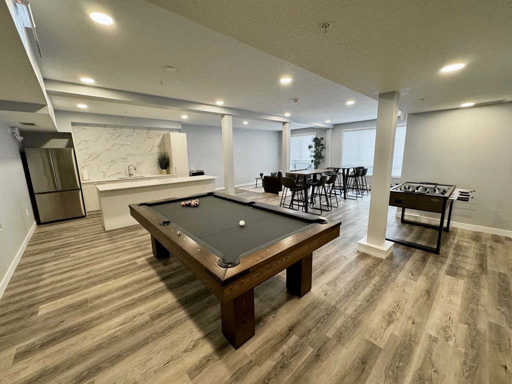 a game room with a pool table and a bar