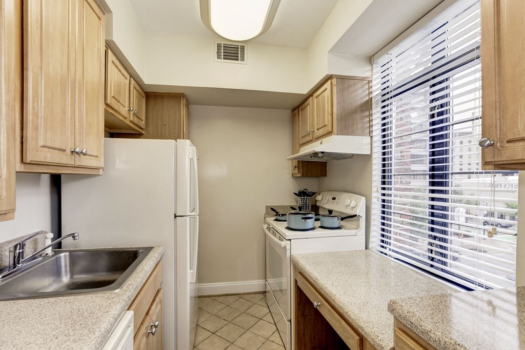 A kitchen with wooden cabinets and a white refrigerator.