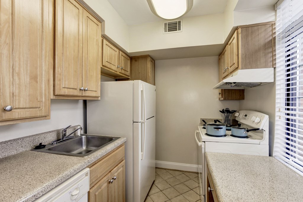 A kitchen with a sink, refrigerator, and stove.