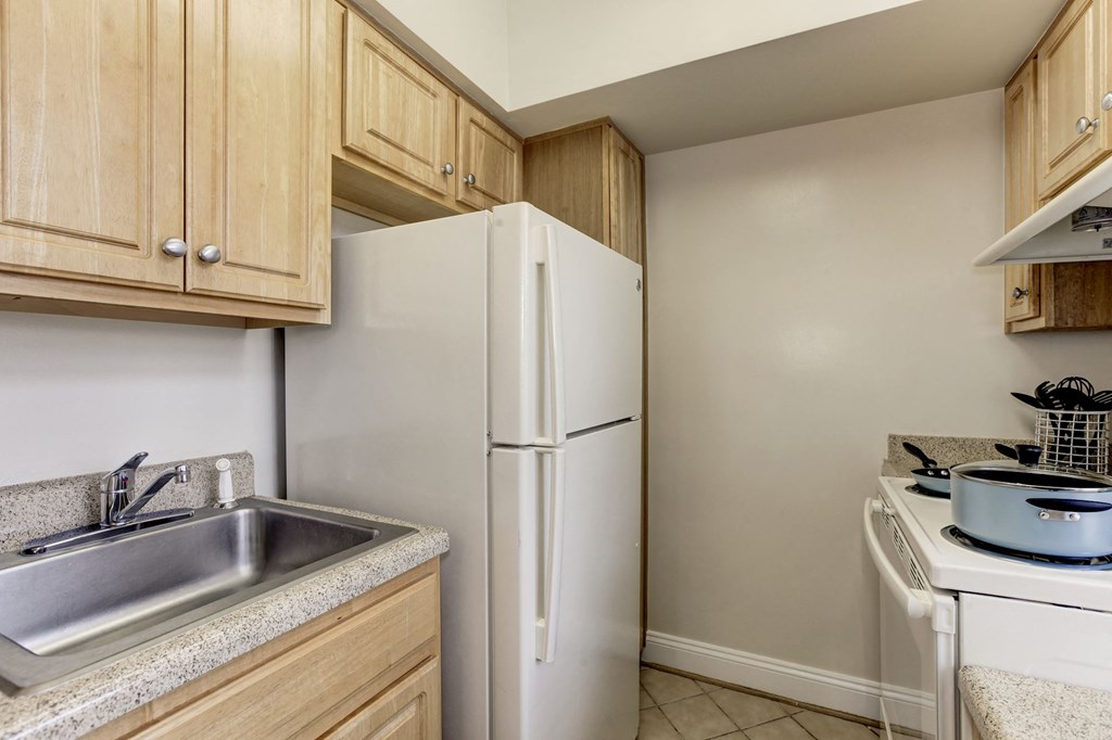 A kitchen with a white refrigerator, a stove, and a sink.